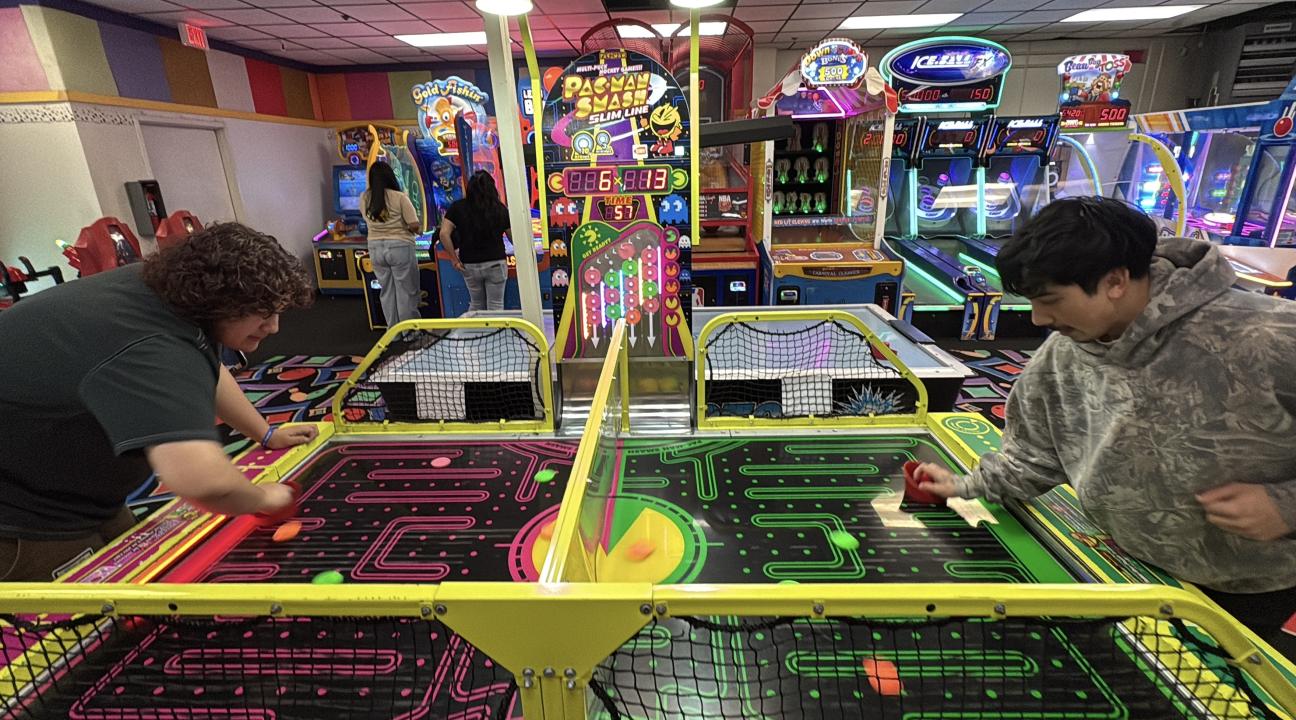 Two guys having fun playing air hockey