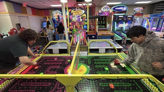 Two guys having fun playing air hockey